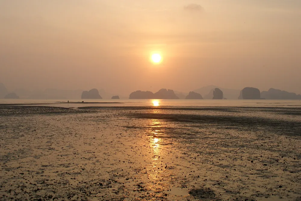 Phang Nga Bay at sunset — limestone karsts rising from the sea
