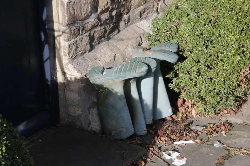 Ordinary green wellington boots left by a doorstep