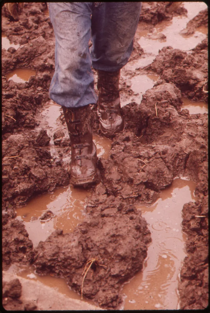 A farmer's mud-caked rubber boots after heavy rain (archival photo)