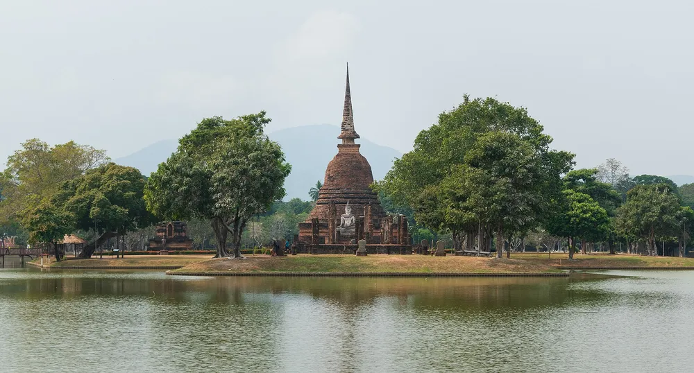 วัดสระศรี เจดีย์ทรงลังกากลางสระน้ำ มีภูเขาเป็นฉากหลัง