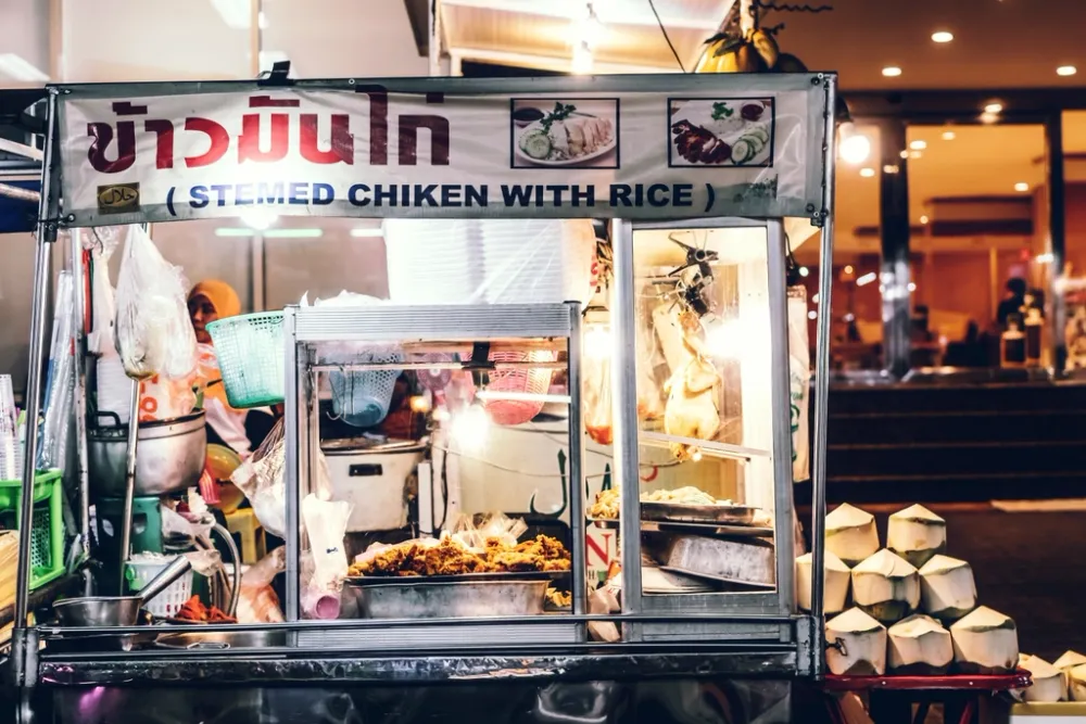 A Thai street food cart selling steamed chicken with rice