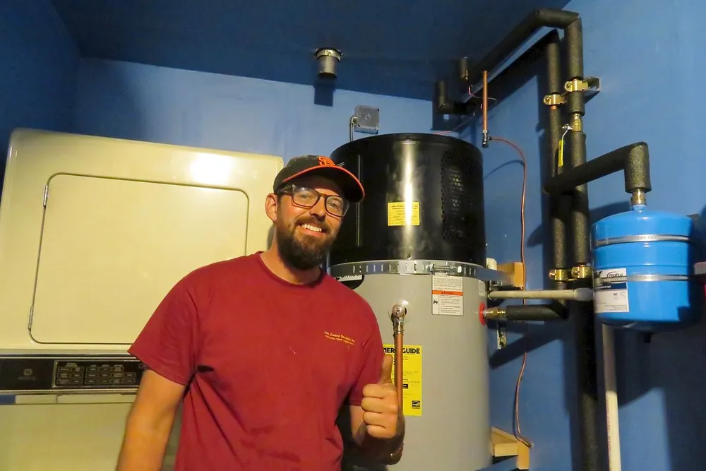 A technician installing a water heater — correct installation and grounding are the heart of safety