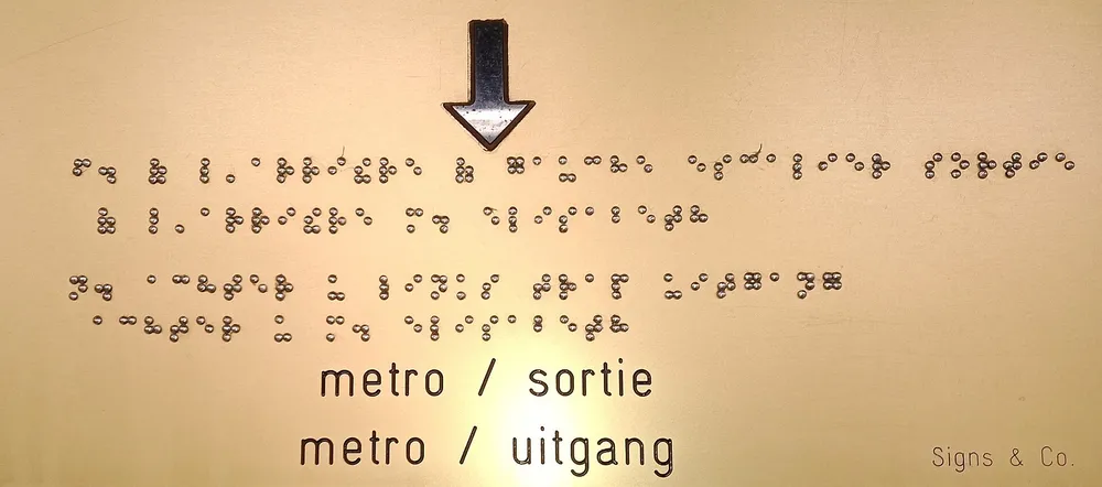 A sign with braille alongside printed text