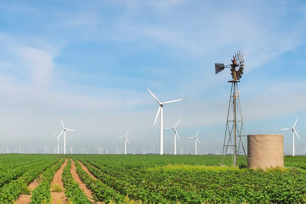 Wind turbines generating electricity in an open field