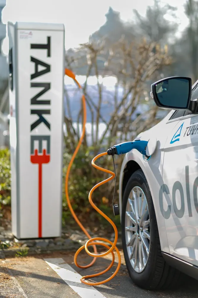 An electric car charging at a public charging station
