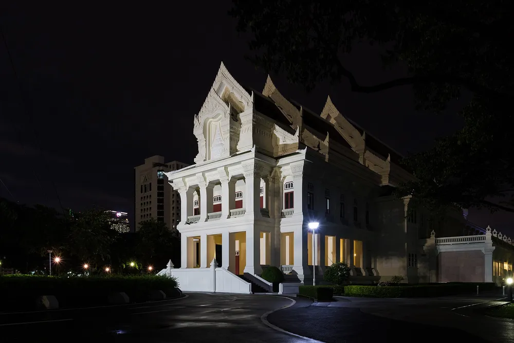Thai-style university building lit up at night