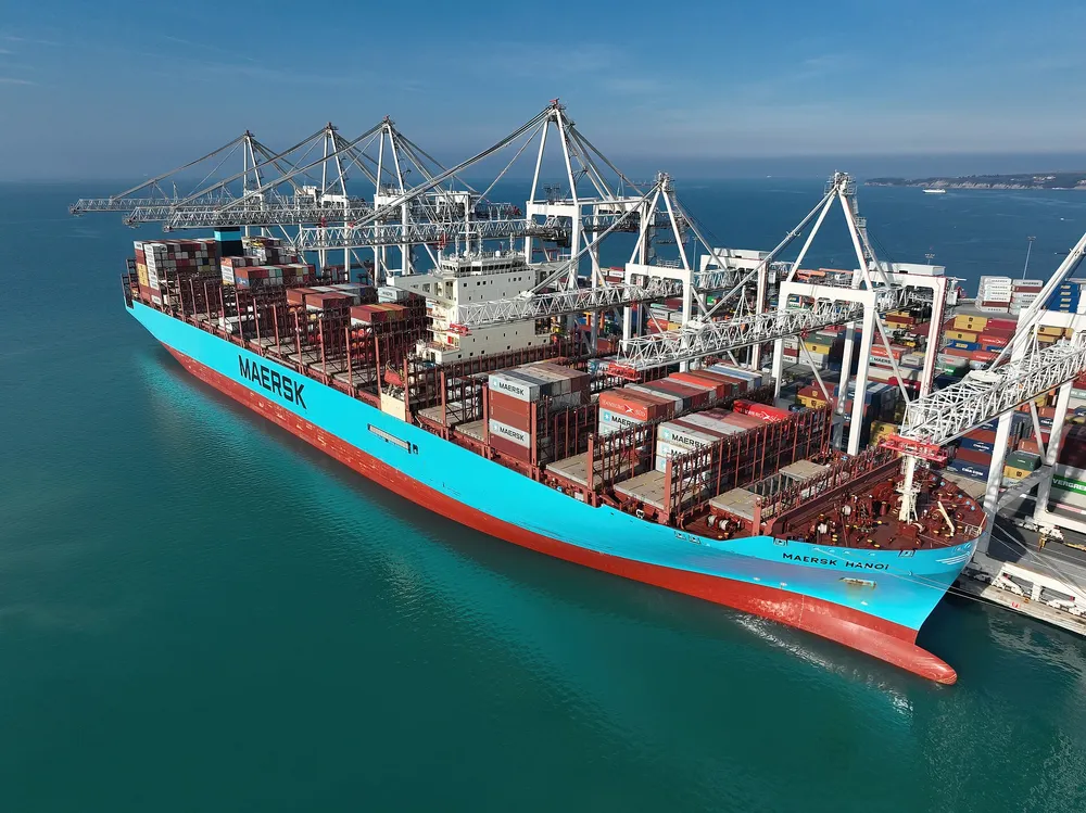 A large container ship being loaded at a port